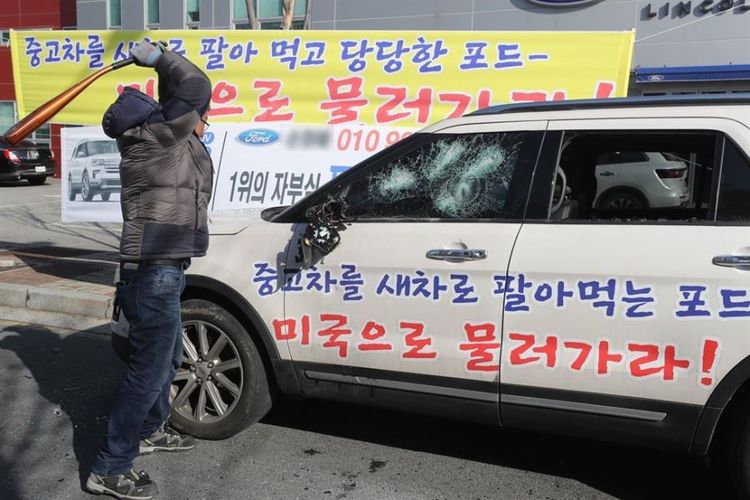 Jang Dong-min, mengayunkan pemukul bisbol ke mobilnya sendiri sebagai bentuk protes di depan kantor diler Ford di Jeonju, Provinsi Jeolla, Korea Selatan, Minggu (20/1/2019).