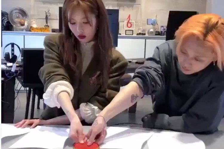 HyunA dan EDawn saat menandatangani kontrak mereka menggunakan cap jempol.