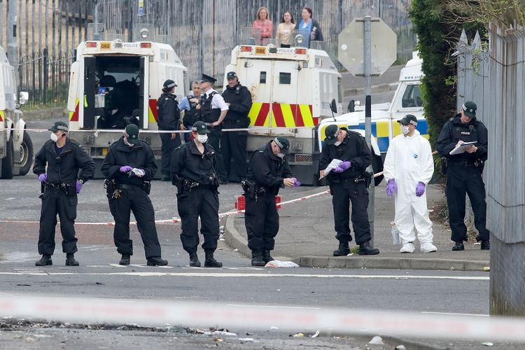 Petugas kepolisian Irlandia Utara memeriksa lokasi kerusuhan yang menewaskan seorang jurnalis di Creggan, Londonderry, Kamis (18/4/2019) malam.