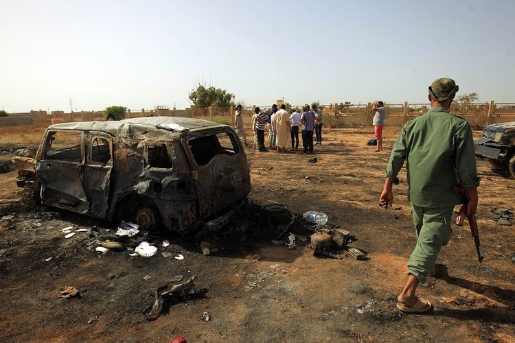 Penduduk kota Benghazi melihat lokasi serangan bom mobil yang terjadi di tengah upacara pemakaman mantan komandan pasukan militer Libya, pada Kamis (11/7/2019).