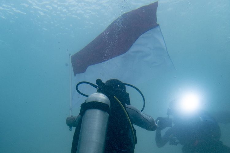 Suasana pengibaran bendera di bawah laut oleh penyandang disabilitas.