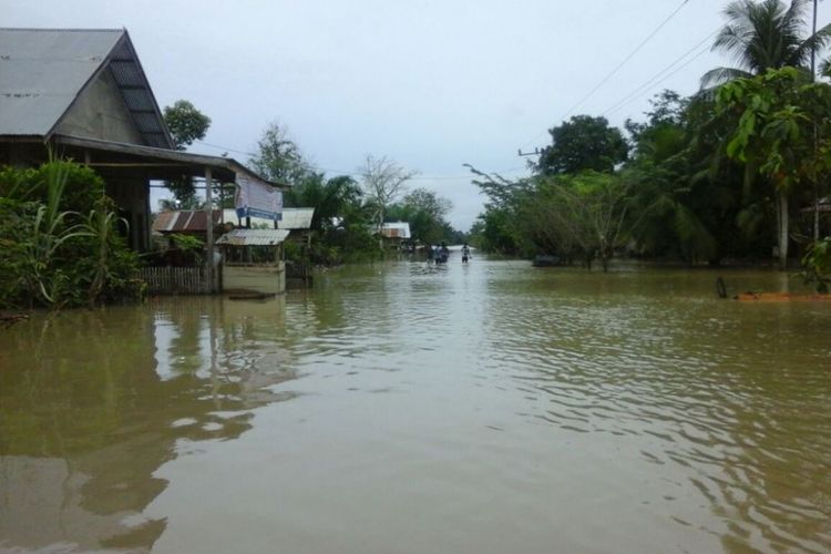 Warga melintas di lokasi banjir Desa Trieng Krueng Kreh, Kecamatan Pirak Timu, Kabupaten Aceh Utara, Kamis (14/1/2018).