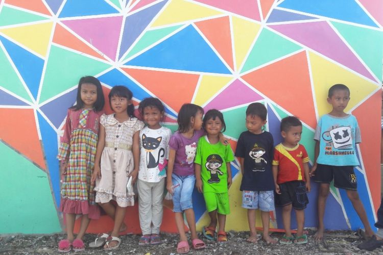 Sejumlah anak berpose di depan dinding yang telah dicat di RW 04 Kamal Muara, Jakarta Utara, Rabu (14/3/2018).