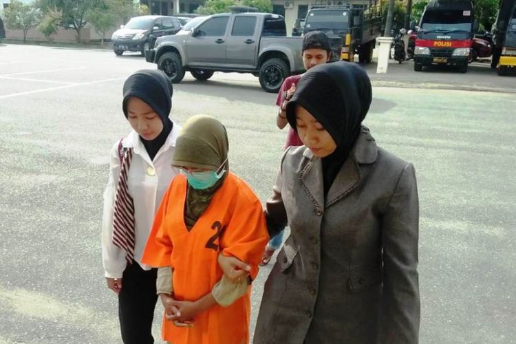 Polisi wanita menggiring N, tersangka yang diduga mencabuli lima anak pria dan wanita di Mapolres Aceh Utara, Jumat (1/2/2019)