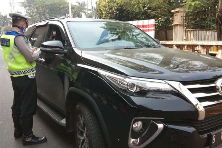 Polisi memberhentikan sebuah mobil bermerek Toyota Fortuner berwarna hitam dengan pelat nomor B 100 NAR di ruas Jalan MT Haryono ke arah Jalan Gatot Subroto, Jakarta, Rabu (1/8/2018). Petugas kepolisian mulai memberlakukan penindakan berupa tilang terhadap pengendara mobil yang melanggar di kawasan perluasan sistem ganjil-genap.