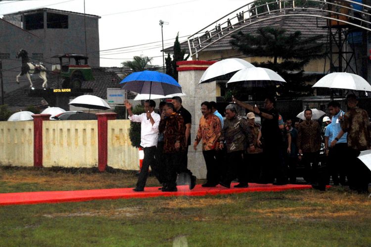 Presiden Joko Widodo (kiri) melambaikan tangan kepada warga saat tiba di Lapang Sekarwangi, Cibadak, Sukabumi, Jawa Barat, Sabtu (7/4/2018).