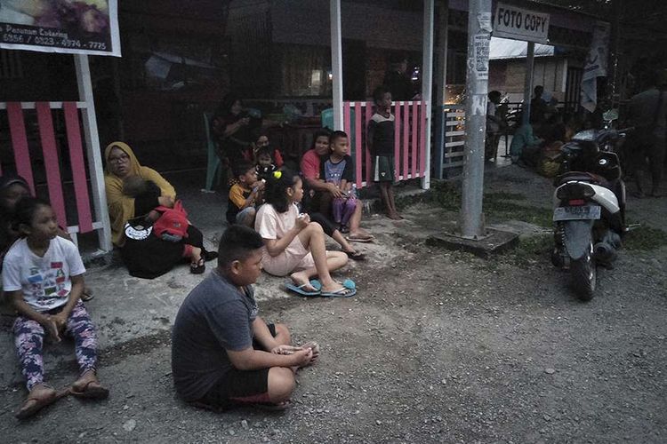 Warga berada di luar rumah mereka setelah terjadinya gempa di Labuha, Maluku Utara, Minggu (14/7/2019). Gempa bumi dengan kekuatan magnitudo (M) 7,2 terjadi sekitar pukul 16.10 di 62 kilometer sebelah timur laut Labuha, Maluku Utara.