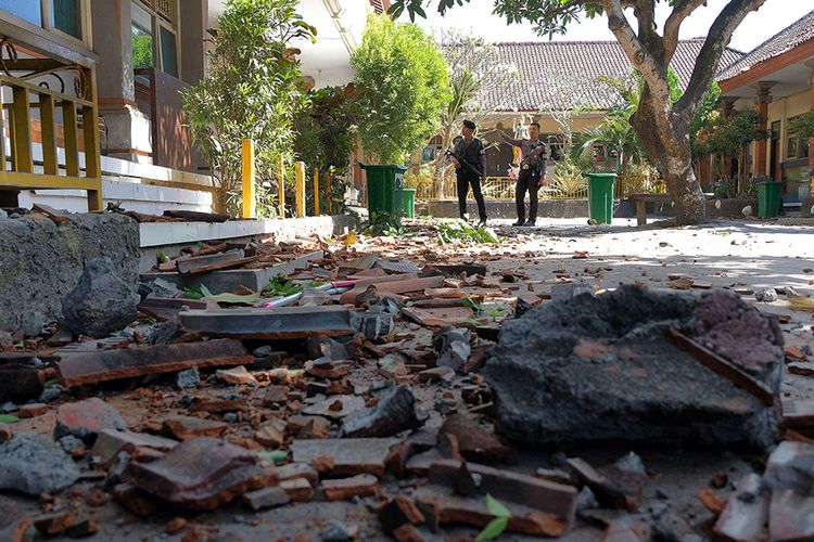 Polisi melihat kondisi bangunan SD No. 1 Ungasan  yang rusak di bagian atap akibat gempa bumi di Badung, Bali, Selasa (16/7/2019). Gempa berkekuatan magnitudo 6 (selanjutnya dilakukan pemutakhiran menjadi magnitudo 5,8) yang berlokasi di wilayah Samudera Hindia Selatan Bali-Nusa Tenggara tersebut mengakibatkan genteng sekolah runtuh sehingga menyebabkan seorang guru dan tiga siswa terluka.
