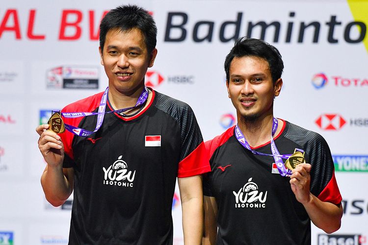 Ganda putra Indonesia Hendra Setiawan (kiri) dan Mohammad Ahsan menunjukan medali emas usai mengalahkan ganda putra Jepang Takuro Hoki dan Yugo Kobayashi pada babak final Kejuaraan Dunia Bulu Tangkis 2019 di St Jakobshalle, Basel, Swiss, Minggu (25/8/2019). Ahsan/Hendra menjadi juara dunia ganda putra usai menang dengan skor 25-23, 9-21, 21-15.