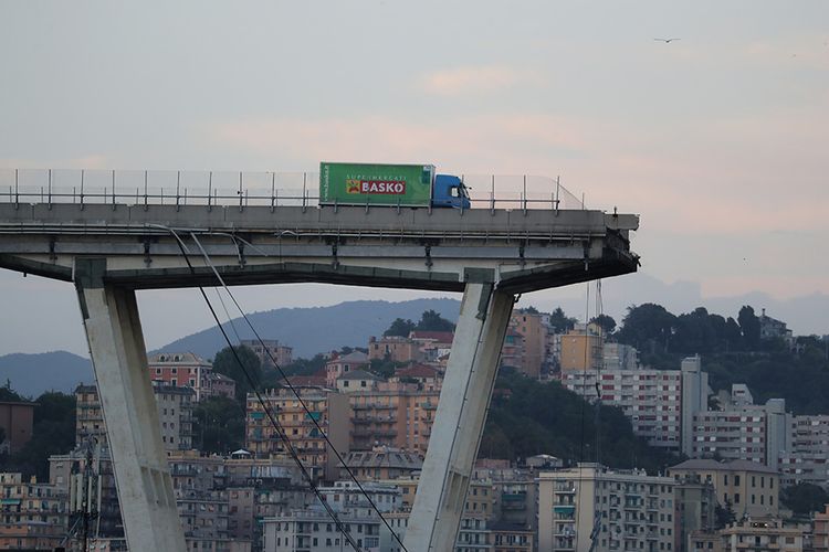 Kondisi Jembatan Morandi di Kota Genoa, Italia, yang ambruk pada Selasa (14/8/2018). Kantor berita ANSA menyebut sedikitnya 35 orang tewas akibat ambruknya salah satu seksi jembatan sepanjang 1.100 meter itu setelah hujan lebat yang mengguyur Selasa siang, waktu setempat.