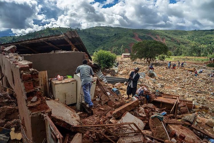 Seorang pria di tengah rumah yang hancur akibat terjangan topan Idai di Chimanimani, Zimbabwe, Selasa (19/3/2019). Ratusan orang tewas dan lainnya hilang di Mozambik dan Zimbabwe setelah topan Idai membawa serta banjir bandang dan angin kencang, 17 Maret lalu.
