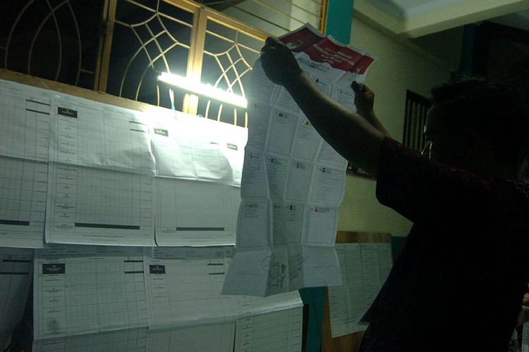Anggota KPPS melakukan penghitungan surat suara di TPS 09 Kelurahan Mangkukusuman, Tegal, Jawa Tengah, Rabu (17/4/2019) malam.