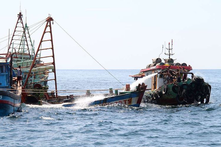 Sejumlah anak buah kapal bantu menyemprotkan air menggunakan mesin pompa ke dalam kapal nelayan Vietnam saat penenggelaman di Pulau Datuk, Kabupaten Mempawah, Kalimantan Barat, Sabtu (4/5/2019). Kementerian Kelautan dan Perikanan menenggelamkan 13 dari 51 kapal nelayan asing asal Vietnam yang ditangkap karena mencuri ikan di Perairan Indonesia.