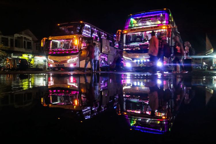 Pemudik menuju bus antarkota antarprovinsi (AKAP) di Lhokseumawe, Aceh, Sabtu (25/6/2019) malam. Sejumlah pemudik tujuan berbagai daerah di Sumatera dan Pulau Jawa memilih mudik lebih awal untuk menghindari kemacetan dan lonjakan harga tiket menjelang Lebaran 2019.