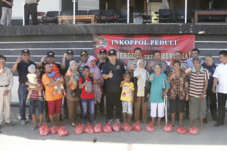Warga Kota Kupang NTT berpose bersama pejabat dari Induk Koperasi Polisi Mabes Polri, usai menerima bantuan gula gratis, Rabu (23/8/2017)