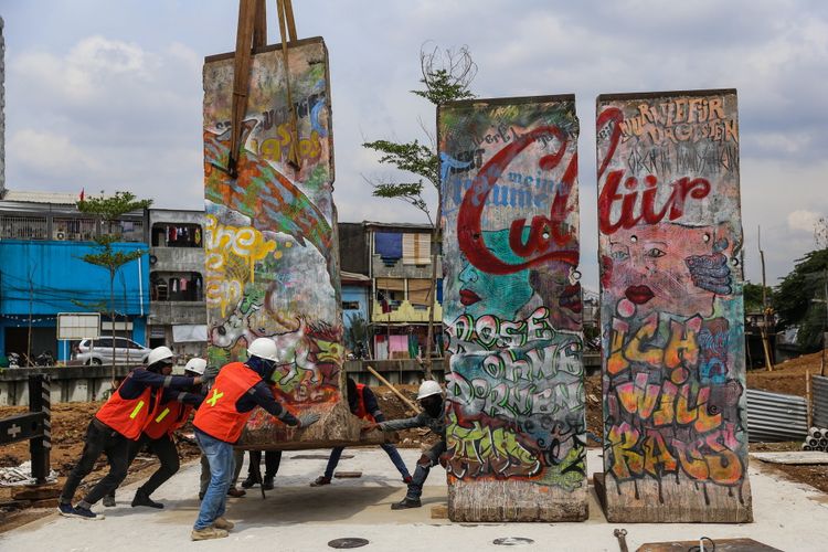 Sejumlah pekerja melakukan pemasangan batu pecahan tembok berlin di kawasan Ruang Publik Terpadu Ramah Anak (RPTRA) dan Ruang Terbuka Hijau (RTH) Kalijodo, Jakarta Barat, Selasa (26/9/3017). Karya seni instalasi ini bernama Patung Menembus Batas terdiri dari empat pecahan tembok Berlin dan 14 patung baja hasil karya dari seniman Teguh Osternik.