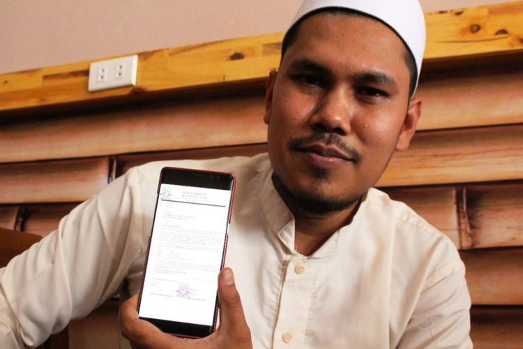 Ketua Dewan Pimpinan Ikatan Dai Aceh, Marsyuddin Ishaq menunjukan surat undangan tes baca Al Quran untuk Joko Widodo dan Prabowo Subianto di salah satu kafe di Lhoksukon, Aceh Utara, Selasa (1/1/2019)