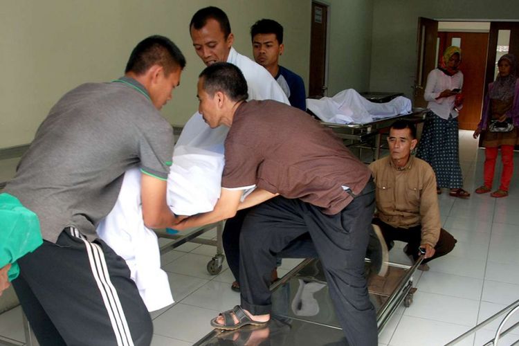 Petugas medis mengangkat jenazah korban yang meninggal akibat meminum minuman keras (miras) jenis oplosan, di sebuah rumah sakit di Bandung, Jawa Barat, Senin (9/4/2018). Korban miras jenis oplosan di daerah tersebut terus bertambah, dari data terakhir sebanyak 23 orang dilaporkan tewas dengan indikasi keracunan.