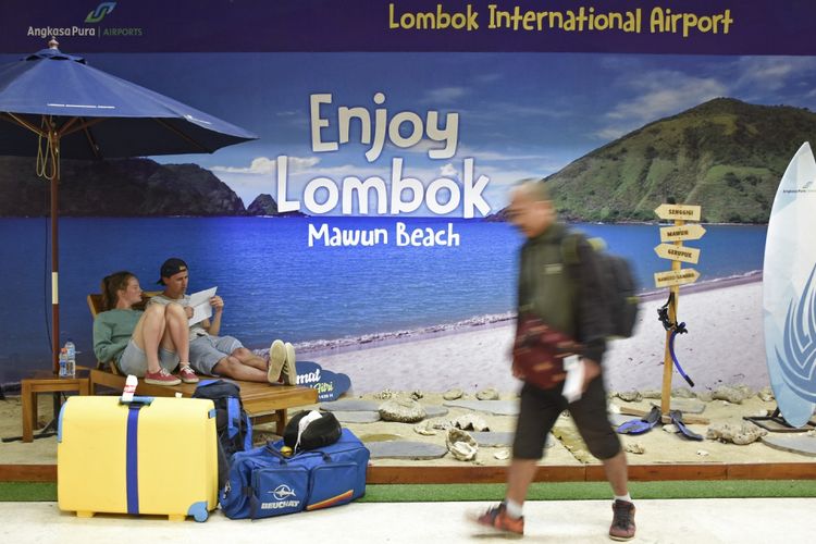 Dua wisatawan manca negara yang penerbangannya dibatalkan duduk santai di Photobooth Lombok International Airport (LIA) di Praya, Lombok Tengah, NTB, Jumat (29/6). Sejumlah maskapai membatalkan jadwal penerbangannya dari Bandara LIA menuju Bandara Ngurah Rai di Bali diantaranya GA704 dan IW 1851 akibat aktivitas vulkanik Gunung Agung. ANTARA FOTO/Ahmad Subaidi/Spt/18