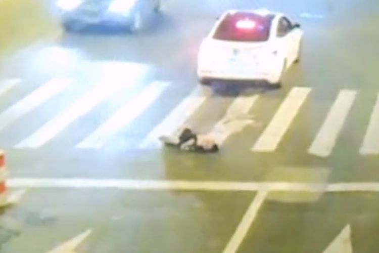 Tubuh pria mabuk tergeletak setelah terlindas dan sempat terseret mobil saat tidur di tengah jalan di China.