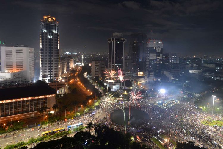 Suasana pesta kembang api pada malam tahun baru 2018 di kawasan Bundaran Patung Kuda, Jakarta Pusat, Minggu(31/12/2017).