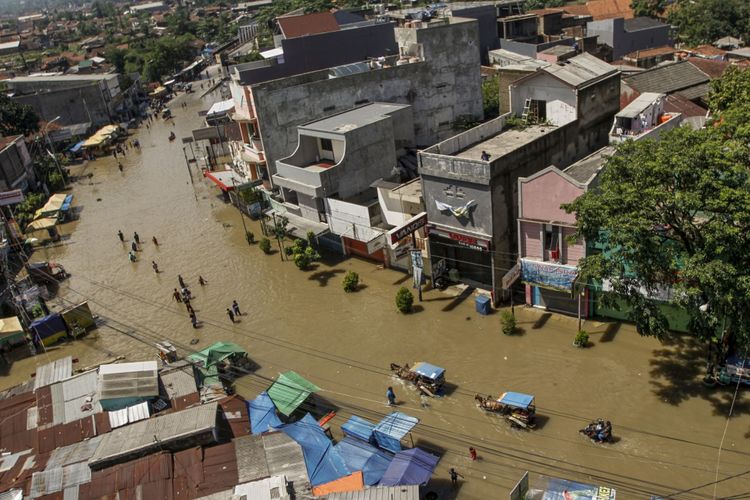 Warga menembus banjir yang melanda ruas Jalan Raya Dayeuhkolot, Kabupaten Bandung, Jawa Barat, Jumat (17/11). Sedikitnya 1.033 jiwa terdampak banjir masih mengungsi di beberapa posko BPBD Kabupaten Bandung. Sebanyak 4.097 unit rumah, 10 gedung sekolah, dan 27 tempat ibadah di tiga kecamatan terendam banjir akibat curah hujan yang tinggi dan meluapnya Sungai Citarum. ANTARA FOTO/Novrian Arbi/kye/17