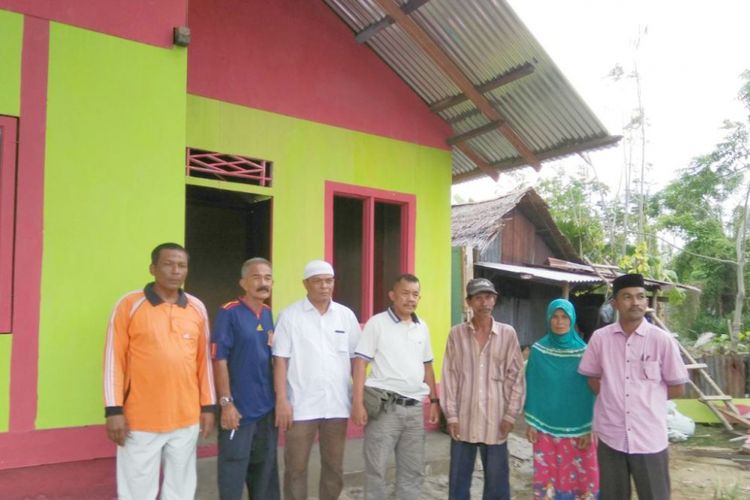 Ikhwan (paling kanan) berdiri di depan rumah yang telah direhab di Desa Uteun Bayi, Kecamatan Banda Sakti, Kota Lhokseumawe, Minggu (15/4/2018)