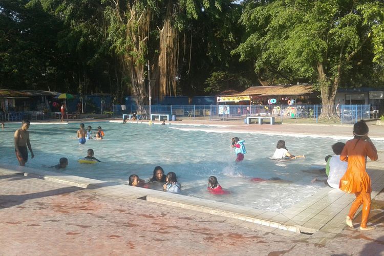 Pengunjung memadati kolam renang Tirtomoyo Kelurahan Manahan, Kecamatan Banjarsari, Solo, Jawa Tengah, Senin (9/7/2018).