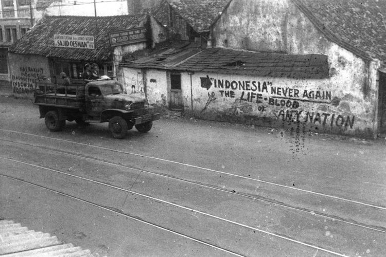  Truk tentara sekutu melintasi dinding-dinding bertuliskan semboyan perjuangan Indonesia, diduga di kawasan Senen, Jakarta Pusat. Bung Tomo yang
berkunjung ke Jakarta setelah pertempuran Surabaya melihat deretan truk yang membawa beratus-ratus orang preman dan serdadu Serikat, bersorak-sorak seolah mereka itu telah bertempur mati-matian dan berhasil memasuki serta merebut Kota Jakarta. Sasaran serdadu NICA dan Batalyon X yang terkenal ganas itu bukan cuma Pemuda Pelopor, tetapi juga rakyat biasa dan para abang Betawi. Makanan dan uang yang dibawa rakyat dirampasnya, kenang wartawan Merdeka Rosihan Anwar. Fotografer Antara, Abdoel Kadir Said, pernah tertangkap mengenakan lencana Merah Putih. Ia dipaksa menelan benda dari seng itu. 