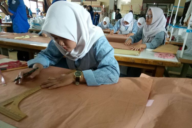 Salah satu siswa SMKN 9 Bandung tengah mendesain baju yang akan dibuatnya.