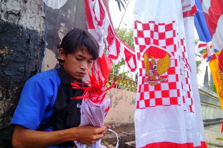 Uus merapikan bendera dagangannya di Jalan Merdeka Utama, Kota Lhokseumawe, Jumat (4/8/2017)
