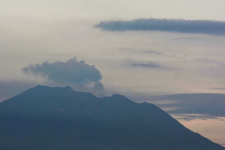 Gunung Agung mengeluarkan asap terlihat dari Denpasar, Bali, Jumat (22/2/2019). Terjadi dua kali letusan Gunung Agung pada Jumat (22/2/2019) pukul 16.31 Wita dan 17.01 Wita yang mengeluarkan asap kawah hingga setinggi 700 meter. ANTARA FOTO/Fikri Yusuf/aww.