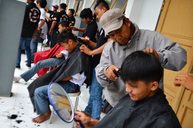 Sejumlah siswa Sekolah Cukur Lanang memotong rambut siswa pada kegiatan belajar mengajar praktek lapang di SMK Negeri 2 Garut, Jawa Barat, Selasa (3/10). Sekolah keterampilan potong rambut yang didirikan oleh Badan Usaha Milik Desa (Bumdes) Baraya Desa Banyuresmi dengan jumlah siswa 18 orang angkatan pertama bertujuan untuk mengurangi penggangguran dan membuka wawasan di bidang usaha pangkas rambut atau barbershop. ANTARA FOTO/Adeng Bustomi/foc/17.