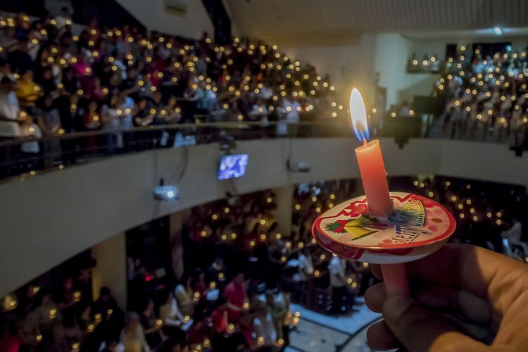 Jemaat menyalakan lilin saat prosesi misa malam Natal di GKI Maulana Yusuf, Bandung, Jawa Barat, Minggu (24/12/2017) malam. Misa malam Natal diikuti seluruh umat kristiani sedunia saat merayakan malam kelahiran Yesus Kristus. 