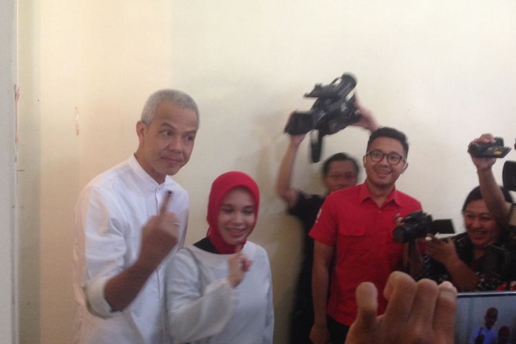 Ganjar Pranowo dan istrinya Siti Atiqoh menujukkan jari kelingking usai mencoblos, Rabu (27/6/2018) pagi tadi. 