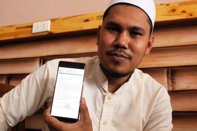 Ketua Dewan Pimpinan Ikatan Dai Aceh, Marsyuddin Ishaq menunjukan surat undangan tes baca Quran untuk Joko Widodo dan Prabowo Subianto di salah satu kafe di Lhoksukon, Aceh Utara, Selasa (1/1/2019)