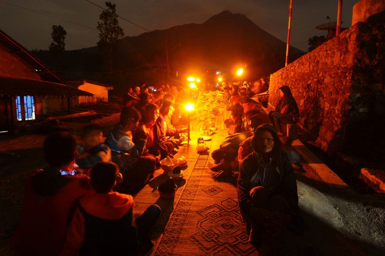 Sejumlah warga berdoa bersama dan menghidangkan 12 macam nasi tumpeng dan tujuh obor saat Tradisi Ngetoke di Stabelan, Tlogolele, Selo, Boyolali, Jawa Tengah, Kamis (24/5). Tradisi yang telah dilakukan turun temurun oleh warga setempat yang bertempat tinggal sekitar 3.5 km dari puncak Gunung Merapi itu bertujuan untuk memohon keselamatan kepada Tuhan Yang Maha Esa jika terjadi erupsi Gunung Merapi. ANTARA FOTO/Aloysius Jarot Nugroho/kye/18. 