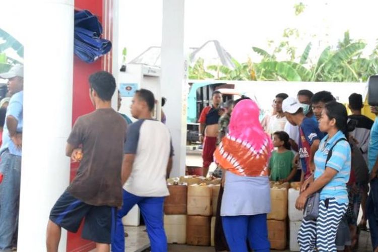 Puluhan warga berkerumun sambil membawa jeriken untuk mengisi bahan bakar minyak di SPBU Desa Lombe, Kecamatan Gu, Sulawesi Tenggara, Jumat (9/11/2018). 