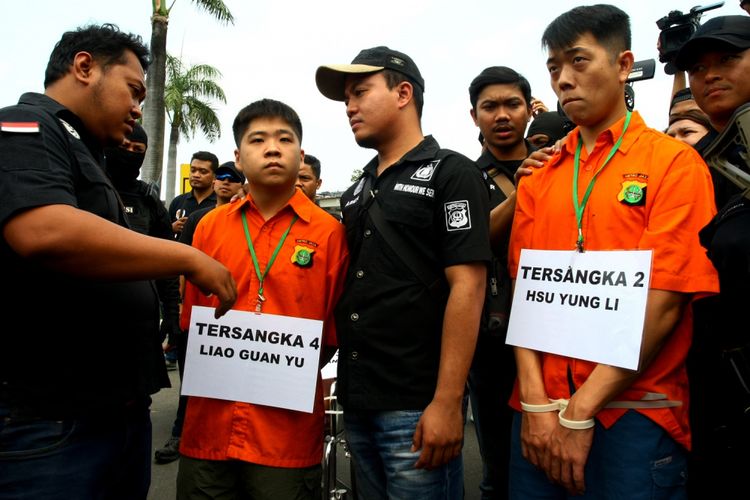 Petugas Polda Metro Jaya meminta dua tersangka penyelundup sabu 1 ton Liau Guan Yu (kedua kiri) dan Hsu Yung Li (kedua kanan) untuk memperagakan rangkaian kejahatan saat rekonstruksi di Bandara Soekarno Hatta, Tangerang, Banten, Kamis (3/8). Pada rekonstruksi tersebut polisi menghadirkan tiga tersangka hidup dan dua tersangka yang tewas yang perannya digantikan polisi dengan 16 adegan yang kesemua adegan merupakan pertemuan para tersangka setibanya di Indonesia pada 4 Juni 2017. ANTARA FOTO/Muhammad Iqbal/ama/17