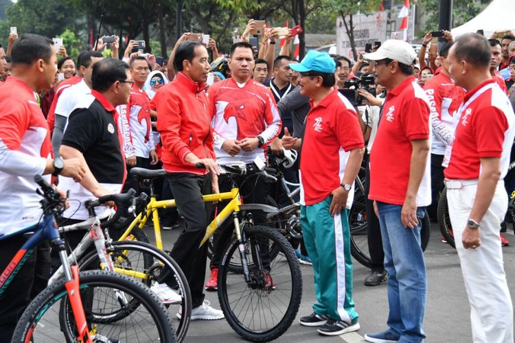 Presiden RI Joko Widodo menggowes sepeda kuning saat acara penyerahan sertifikat hak atas tanah di Jalan MH Thamrin, Jakarta, Minggu (20/8/2017).