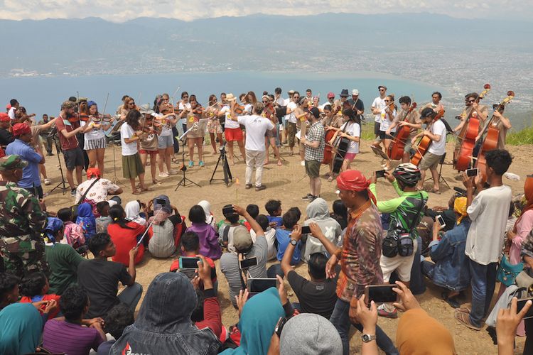 Kelompok musik Orquesta de Camarada de Siero (OCAS) Spanyol menghibur masyarakat saat berkunjung ke Dusun Salena di Palu, Sulawesi Tengah, Kamis (9/8/2018). Selain di Kota Palu, OCAS dalam program Vinculos Untuk Indonesia 2018 juga melakukan lawatan musiknya pada sejumlah daerah di Sulawesi Tengah yakni Kabupaten Sigi dan Parigi Moutong. ANTARA FOTO/Mohamad Hamzah/aww/18. 