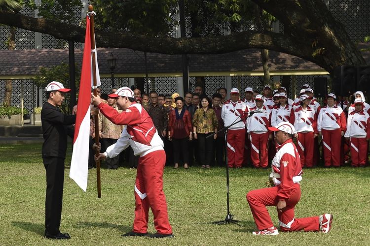 Presiden Joko Widodo (kiri) menyerahkan bendera Merah Putih kepada Ketua Kontingen Indonesia SEA Games XXIX Malaysia Aziz Syamsuddin (kedua kiri) saat upacara pelepasan di halaman Kompleks Istana Kepresidenan, Jakarta, Senin (7/8). Presiden berpesan kepada seluruh atlet Indonesia untuk menunjukkan daya juang tinggi dan sportif saat berlaga dalam SEA Games XXIX di Kuala Lumpur, Malaysia, 19-30 Agustus 2017.