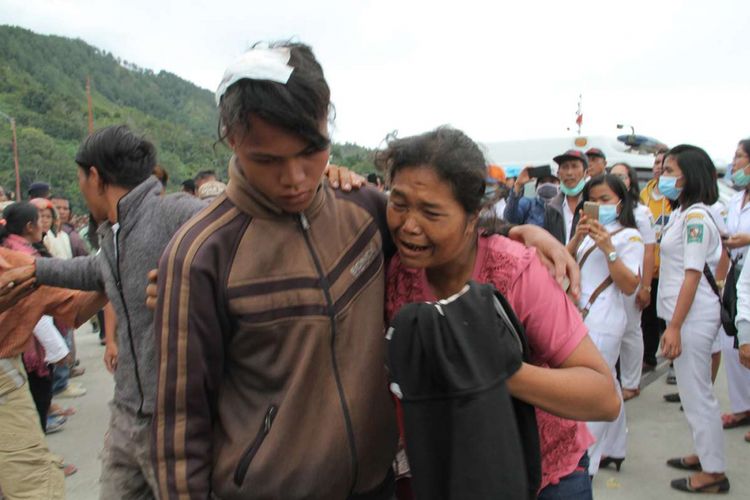 Penumpang KM Sinar Bangun yang selamat dan sempat mendapatkan perawatan (kiri) dibantu anggota keluarganya saat tiba di posko Pelabuhan Tigaras, Danau Toba, Simalungun, Sumatera Utara, Selasa (19/6/2018). KM Sinar Bangun yang mengangkut ratusan penumpang tenggelam di Danau Toba pada Senin sore, dengan dilaporkan 1 penumpang tewas, belasan selamat, dan ratusan lainnya masih dalam proses pencarian.