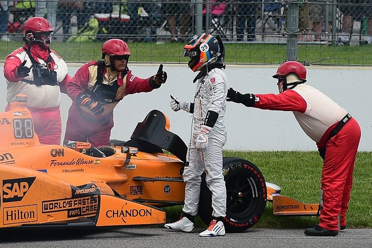 Pebalap Spanyol, Fernando Alonso (dua dari kanan), berdiri di samping mobil McLaren Honda Andretti yang mengalami kerusakan mesim pada balapan Indianapolis 500 ke-101 di Indianapolis Motorspeedway, Minggu (28/5/2017).