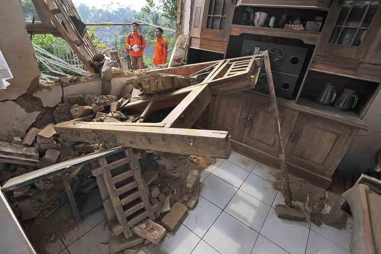 Relawan memeriksa rumah warga yang rusak akibat diguncang gempa di Kampung Karoya, Mandalawangi, Pandeglang, Banten, Sabtu (3/8/2019). Menurut data BPBD Banten satu orang meninggal dan sebanyak 112 rumah rusak berat dan ringan dengan rincian di Lebak sebanyak 12 rumah, di Pandeglang 91 rumah, dan di Serang 9 rumah rusak akibat gempa berkekuatan 7,4 SR yang terjadi Jumat (2/8) malam. ANTARA FOTO/Asep Fathulrahman/ama.