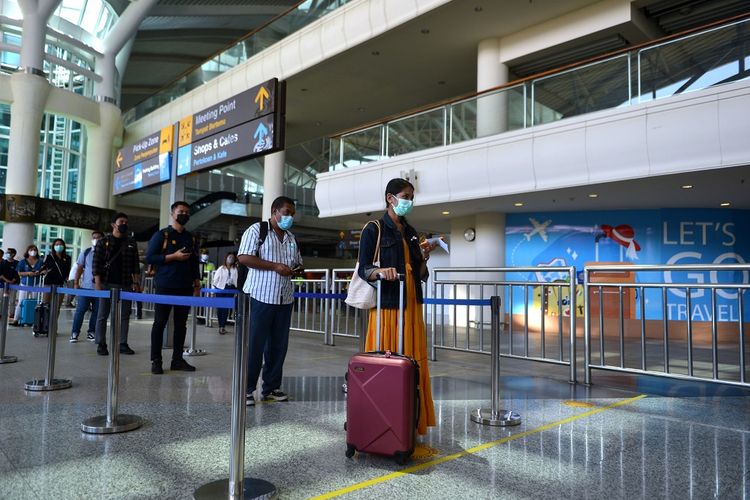 Peserta antre meninggalkan area bandara untuk menuju ke hotel karantina saat kegiatan simulasi penerbangan internasional di Bandara Internasional I Gusti Ngurah Rai, Badung, Bali, Sabtu (9/10/2021). Simulasi tersebut dilakukan untuk memastikan kesiapan petugas dan sarana prasarana serta menguji standar operasional prosedur dalam pelayanan penumpang penerbangan internasional di Bandara Ngurah Rai yang rencananya akan mulai dibuka pada 14 Oktober 2021 mendatang. ANTARA FOTO/Fikri Yusuf/nz