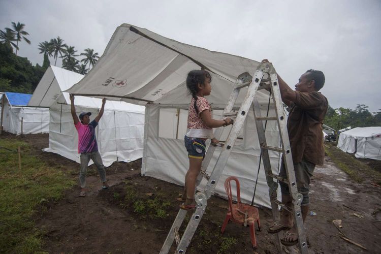 Pengungsi Gunung Agung membangun tenda untuk keluarganya di Desa Rendang, Karangasem, Bali, Sabtu (25/11/2017). Pusat Vulkanologi dan Mitigasi Bencana Geologi (PVMBG) mencatat adanya penurunan kegempaan Gunung Agung pascaletusan freatik pada Selasa (21/11) namun tetap merekomendasikan masyarakat dan wisatawan tidak berada di kawasan berjarak hingga 7,5Km dari kawah gunung yang masih berstatus siaga itu.