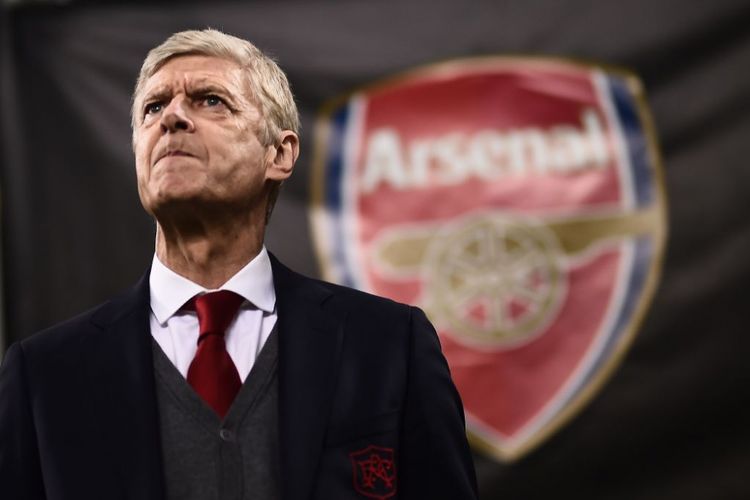 Arsene Wenger dengan logo Arsenal di belakangnya pada laga Liga Europa kontra AC Milan di San Siro, 8 Maret 2018.