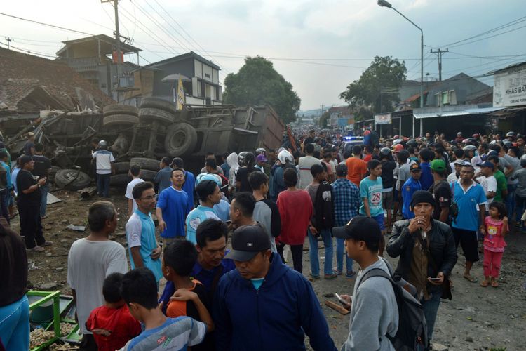 Sejumlah warga melihat truk yang mengalami kecelakaan di jalur tengah Tegal-Purwokerto, Desa Jatisawit, Bumiayu, Brebes, Jawa Tengah, Minggu (20/5/2018). Truk pengangkut gula yang diduga mengalami rem blong tersebut menabrak enam rumah, satu kios buah, 19 sepeda motor, dua mobil sehingga mengakibatkan 11 orang meninggal dan sejumlah warga luka-luka. ANTARA FOTO/Zaenal/ol/kye/18
