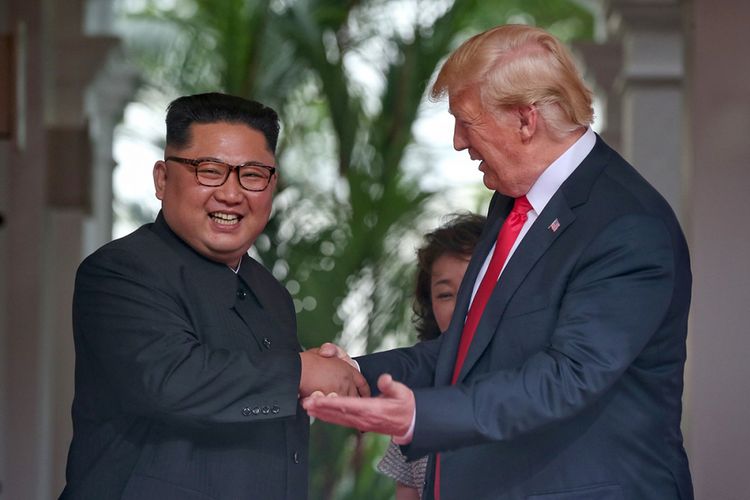Pemimpin Korea Utara Kim Jong Un (kiri) bersalaman dengan Presiden AS Donald Trump pada pertemuan bersejarah antara AS-Korea Utara, di Hotel Capella di Pulau Sentosa, Singapura, Selasa (12/6/2018). Pertemuan ini merupakan yang pertama kalinya bagi pemimpin kedua negara dan menjadi momentum negosiasi untuk mengakhiri kebuntuan permasalahan nuklir yang telah terjadi puluhan tahun.